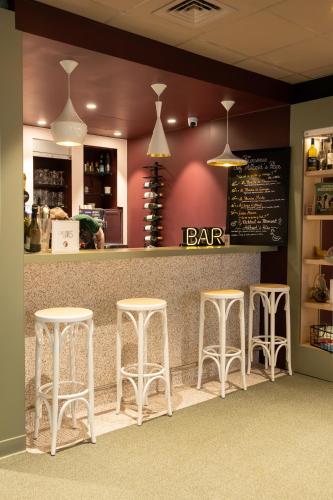 a bar with three stools in front of a counter at ibis Lille Centre Gares in Lille
