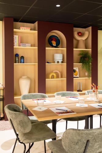 a dining room with a table and chairs and shelves at ibis Lille Centre Gares in Lille