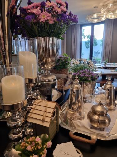 a table with candles and vases with flowers on it at DS Hotel Lusopark in Santa Maria da Feira