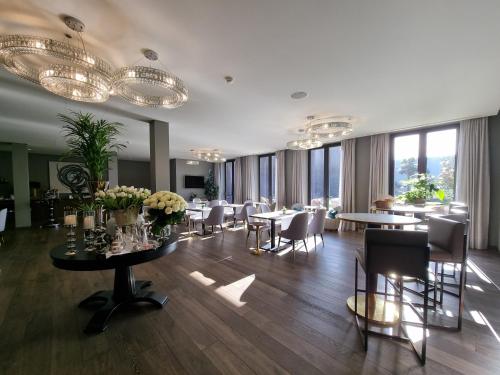 a dining room with tables and chairs and windows at DS Hotel Lusopark in Santa Maria da Feira