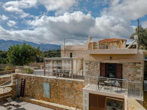 a building with tables and chairs on the balcony at Achlades The Mountain Paradise Villas - Studio with pool! in Aletrouvárion