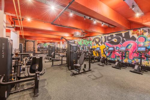 a gym with cardio equipment and a graffiti wall at The Riverside in Kendal