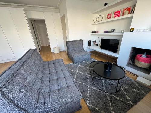 a living room with a couch and a table at Très beau penthouse avec terrasse - Place Albert in Knokke-Heist