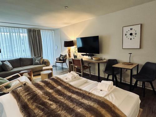 a hotel room with a bed and a living room at Apartment Schlierseeperle in Schliersee