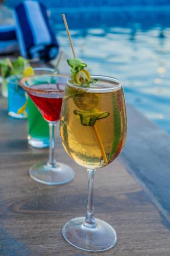 two wine glasses sitting on a table next to a swimming pool at Royal Prime - A City Center Boutique Hotel In Jaipur in Jaipur
