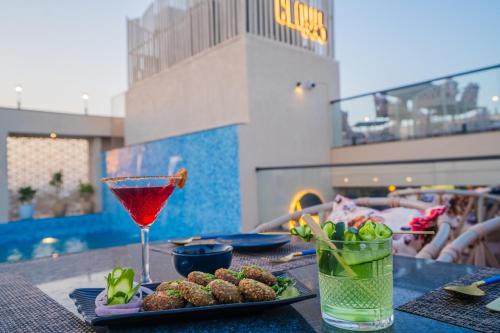 a table with a drink and a plate of food at Royal Prime - A City Center Boutique Hotel In Jaipur in Jaipur