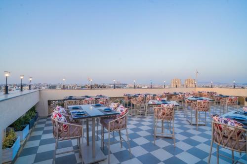 a patio with tables and chairs on a roof at Royal Prime - A City Center Boutique Hotel In Jaipur in Jaipur