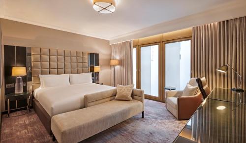 a bedroom with a bed and a couch and a chair at Hyatt Regency London Albert Embankment in London
