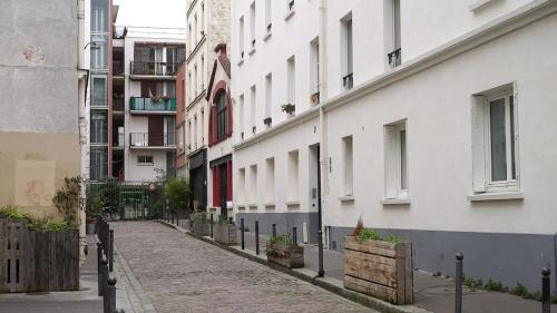 une rue vide dans une ville avec des bâtiments dans l'établissement Peaceful studio in a impasse in Charonne, à Paris