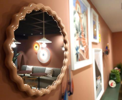 a mirror reflecting a couch in a living room at ibis Lille Centre Gares in Lille