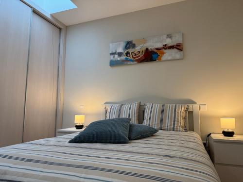 a bedroom with a bed with two lamps and a painting on the wall at Casinhas Dom Afonso by Hotel Dom Afonso in Monção
