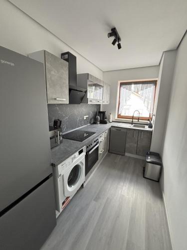 a small kitchen with a sink and a dishwasher at Ferienwohnung HUGO in Penzberg