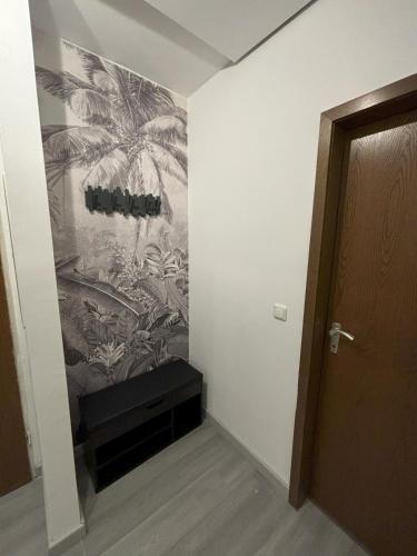 a hallway with a painting of palm trees on the wall at Ferienwohnung HUGO in Penzberg