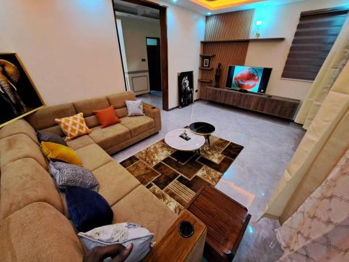 a living room with a couch and a tv at Holiday Home via Entebbe in Nalugala
