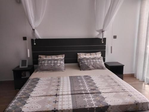 a bedroom with a large bed with a headboard and pillows at Breakfast Included at Pes Villa Diani Beach in Diani Beach