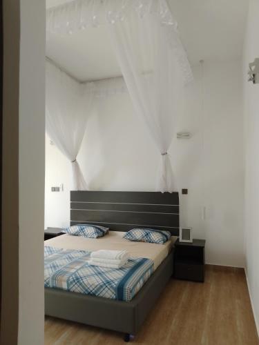 a bedroom with a bed and white walls at Breakfast Included at Pes Villa Diani Beach in Diani Beach