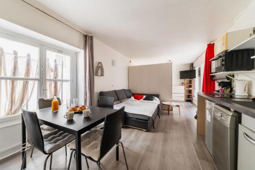 un salon avec une table et un canapé dans l'établissement Grand Studio fonctionnel Republique - Paris 10, à Paris