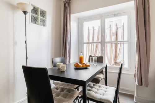 une salle à manger avec une table et une fenêtre dans l'établissement Grand Studio fonctionnel Republique - Paris 10, à Paris