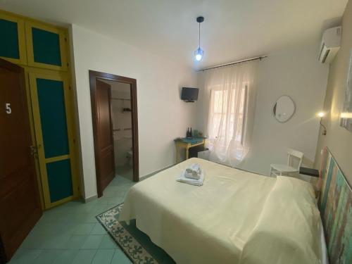 a bedroom with a white bed and a window at Le 5 Torri in Trapani