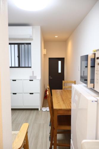 a kitchen and dining room with a table and a refrigerator at 朝潮橋徒歩5分貸切一軒家 in Osaka