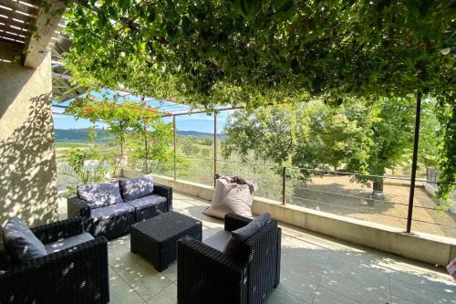 un patio avec deux canapés, une table et des chaises dans l'établissement Maison de vacances Ardèche 8 personnes, à Mirabel