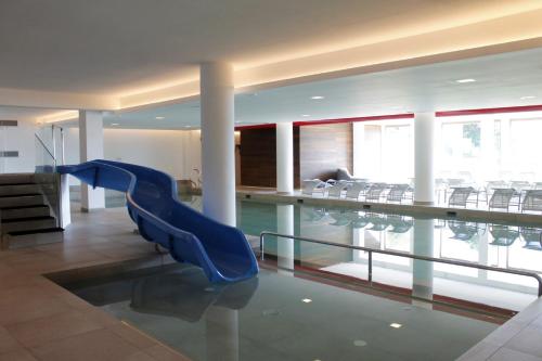 - une piscine avec toboggan bleu dans une maison dans l'établissement ALPINE LOFT - Residence Veronza con piscina, Dolomiti Affitti, à Cavalese