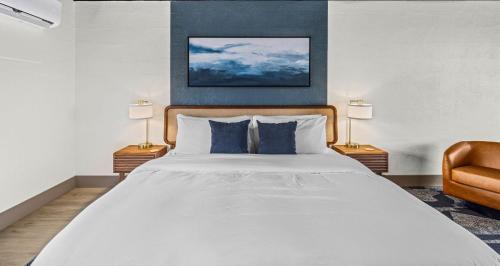 a bedroom with a large white bed with two lamps at Arka Motel in Rogers