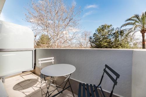 a table and two chairs on a balcony with a window at Hotel Arena Select in Valencia