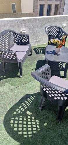 a group of chairs and a table on the grass at PACEVILLE St Julians Apartments in St Julian's