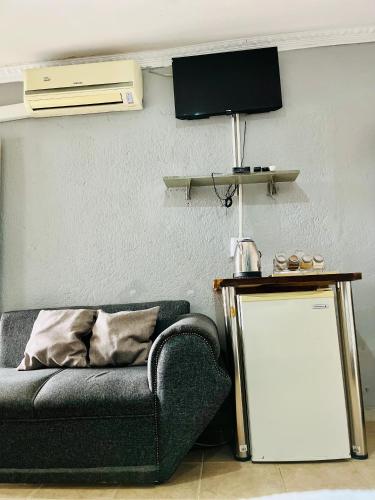 a living room with a couch and a tv at Ashridge Guesthouse & Safaris in Hazyview