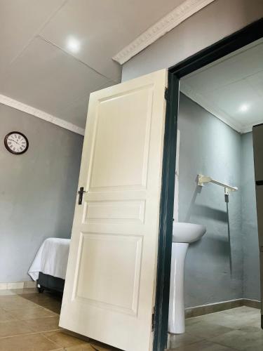 a door leading into a bathroom with a sink at Ashridge Guesthouse & Safaris in Hazyview