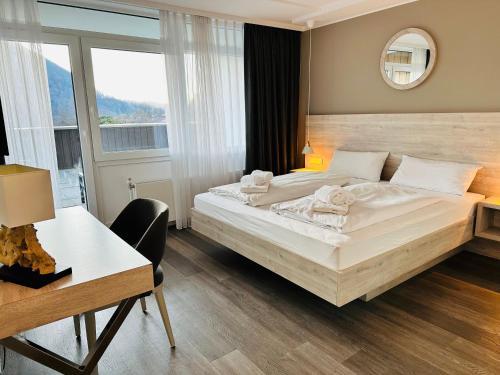 a bedroom with a large white bed and a desk at Apartment Happy Holiday - neu renoviert, gemütlich in ruhiger Lage in Schliersee