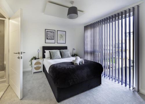 a bedroom with a bed and a large window at Stylish & Modern Flat 2 Min Walk to Ashford Outlet in Ashford