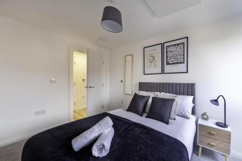 a bedroom with a large bed with black and white at Stylish & Modern Flat 2 Min Walk to Ashford Outlet in Ashford