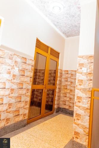 a room with a stone wall and a wooden door at Safa Homes and Residences in Kampala