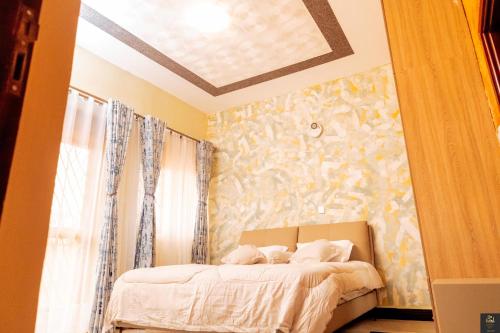 a bedroom with a bed and a wall with flowers at Safa Homes and Residences in Kampala