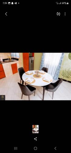 a dining room table with chairs and a white table at Safa Homes and Residences in Kampala