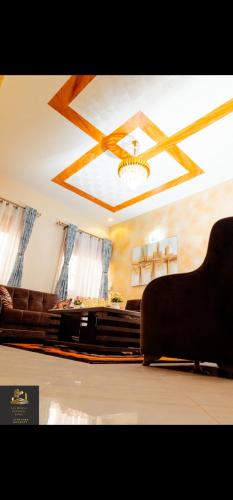 a living room with a couch and a ceiling at Safa Homes and Residences in Kampala