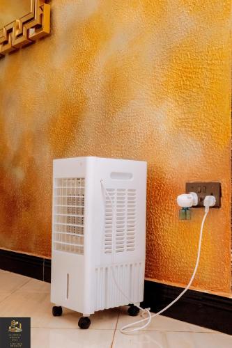 a white air conditioner is plugged into a wall at Safa Homes and Residences in Kampala