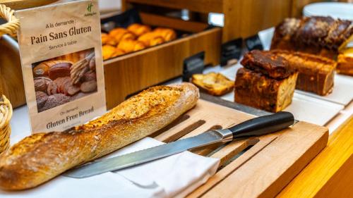 a table with bread and a knife and other bread items at Holiday Inn Dijon Toison D'or by IHG in Dijon
