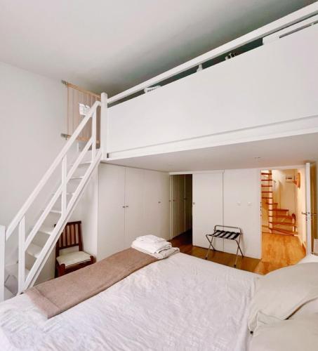 une chambre avec un lit blanc et un escalier dans l'établissement Maison Antoinette Paris - Maison Nomade Chic, à Paris