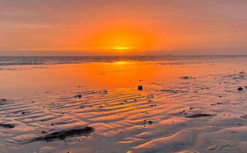 a sunset on the beach with the sun setting at Haus Seepferdchen in Schillig