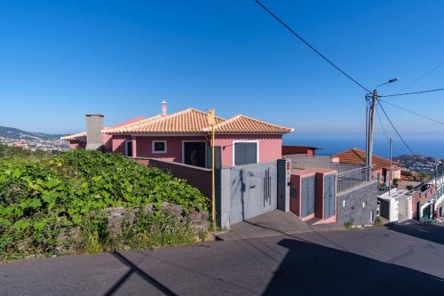 a pink house with a gate on a street at GuestReady - Private Terrace Stay in Funchal