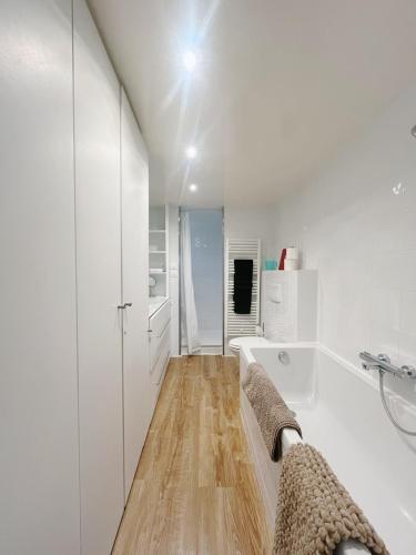 une salle de bain blanche avec une baignoire et un lavabo dans l'établissement Maison Antoinette Paris - Maison Nomade Chic, à Paris