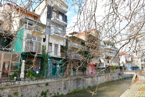 a row of buildings on a stone wall next to a river at Krya Suites in Levádeia