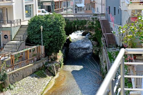 a river with a bridge and stairs in a city at Krya Suites in Levádeia