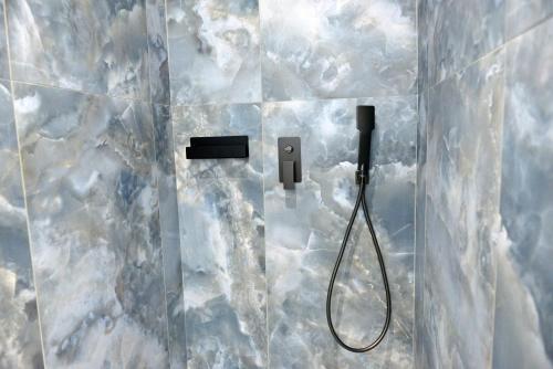 a bathroom with a shower with a shower head and a hose at Krya Suites in Levádeia