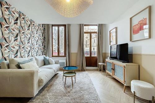 un salon avec un canapé et une télévision dans l'établissement Le Saint Just - Appartement face à la Cathédrale, à Narbonne