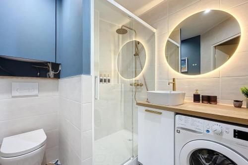 une salle de bain avec un lavabo et une machine à laver dans l'établissement Le Saint Just - Appartement face à la Cathédrale, à Narbonne