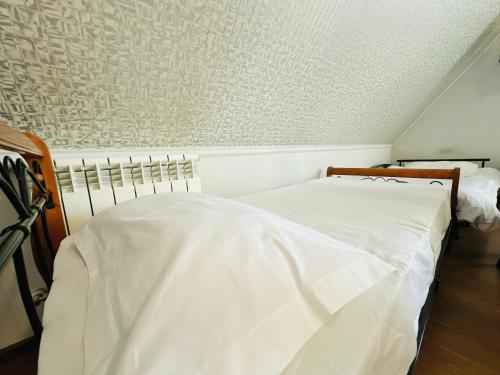 a bedroom with two beds with white sheets at SD Hotel in Yerevan